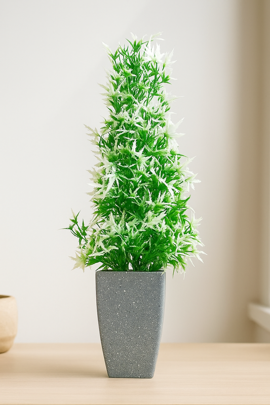Green artificial plant in a gray pot on a wooden surface with a neutral background