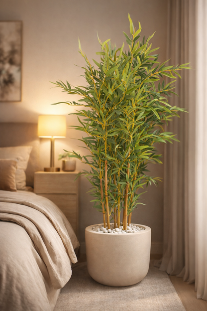 Potted plant in a bedroom setting with a lamp and bed in the background